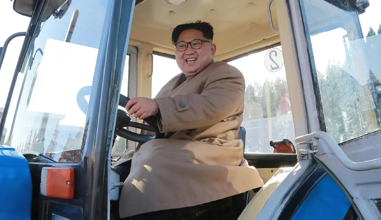 Kim Jong-un saat mengendarai traktor di Kumsong Tractor Factory dalam foto tak bertanggal yang dirilis kantor berita KCNA, (15/11). Traktor buatan dalam negeri ini wujud kemandirian Korut di tengah sanksi internasional. (AFP Photo/Kcna Via Kns/Str)