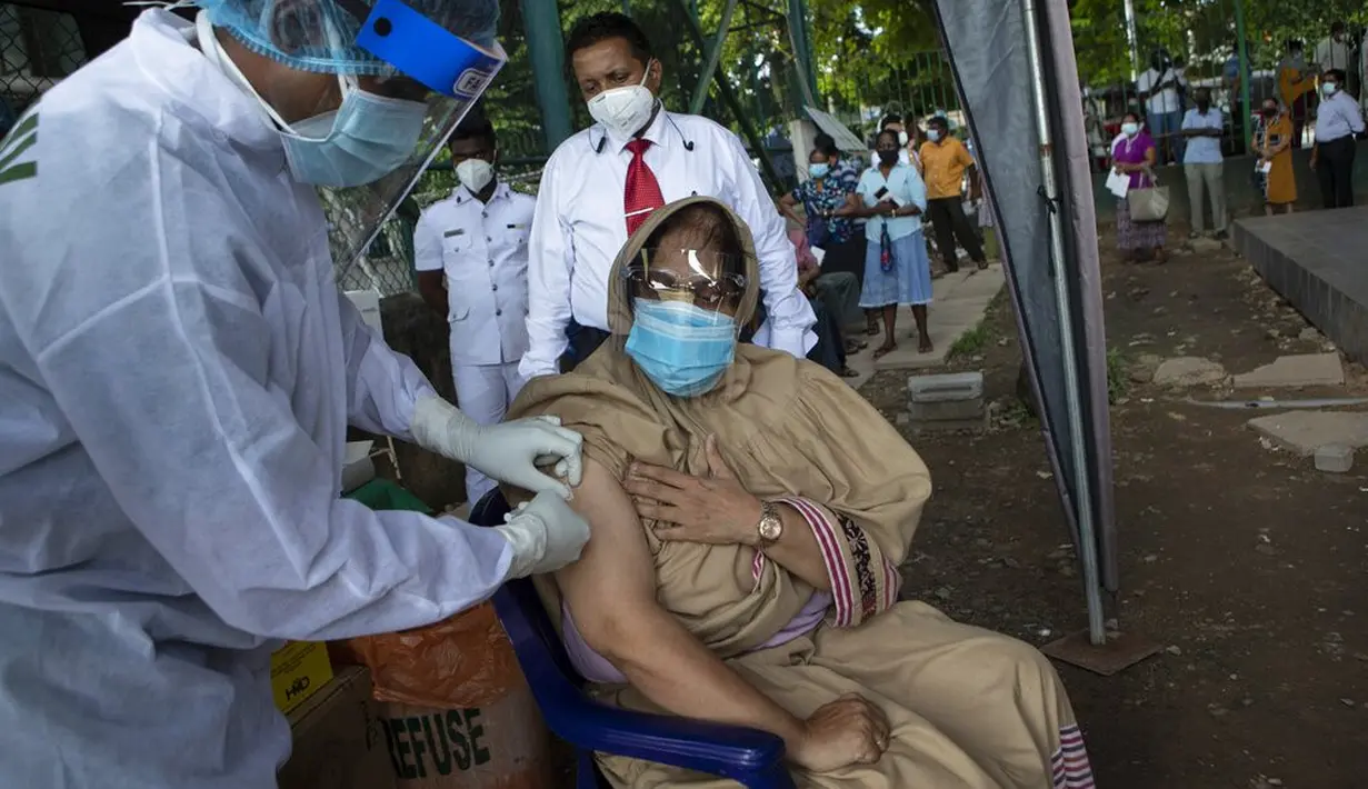 Seorang tentara Sri Lanka memberikan vaksin Pfizer COVID-19 kepada wanita lanjut usia di tempat vaksinasi di Kolombo, Rabu (7/7/2021). Otoritas kesehatan Sri Lanka terpaksa menggunakan Pfizer sebagai dosis kedua karena kelangkaan pasokan vaksin COVID-19 AstraZeneca. (AP/Eranga Jayawardena)