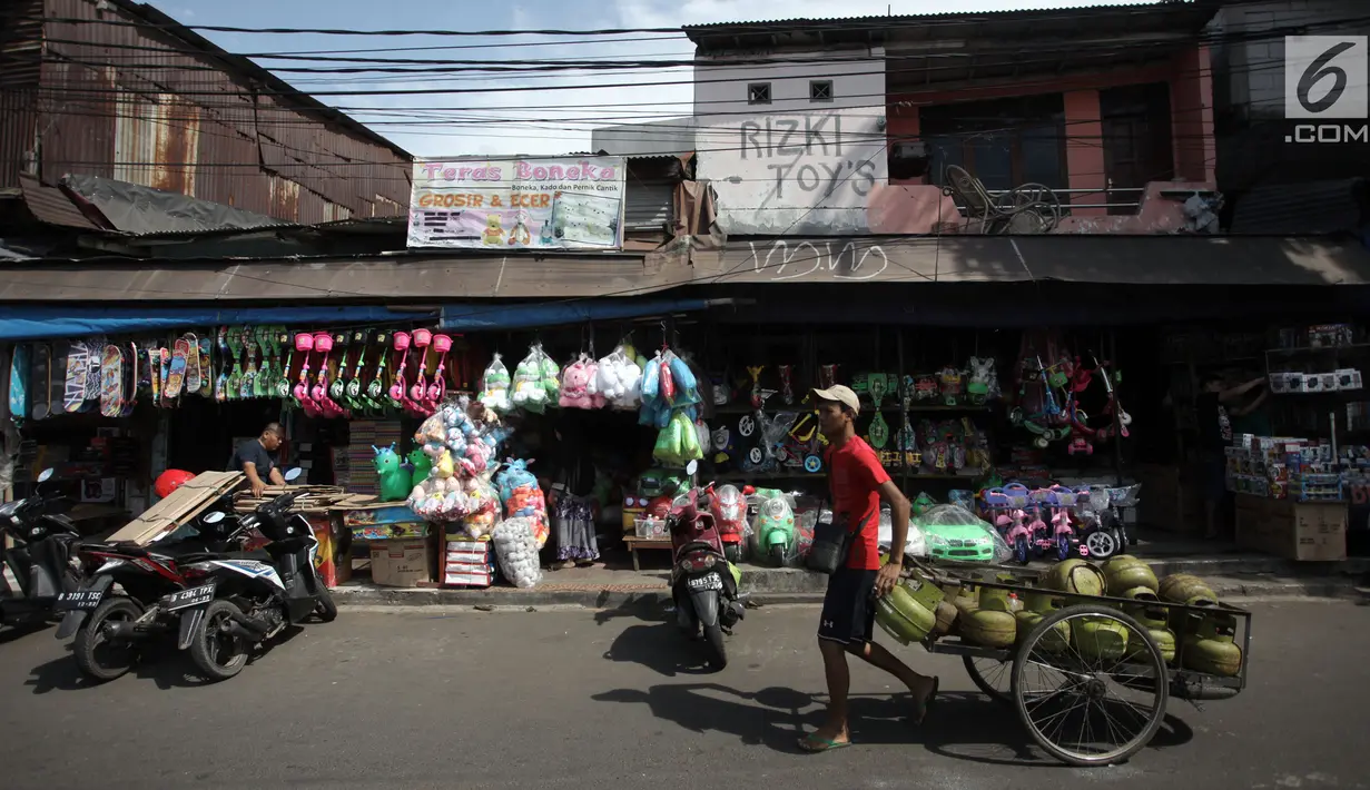 Pedagang gas melintasi kios mainan di Pasar Gembrong, Jakarta, Selasa (9/1). Maret mendatang, Pemprov DKI berencana menggusur kawasan Pasar Gembrong untuk pembangunan tol Becakayu, yang berakhir di Kampung Melayu, Jatinegara. (Liputan6.com/Arya Manggala)