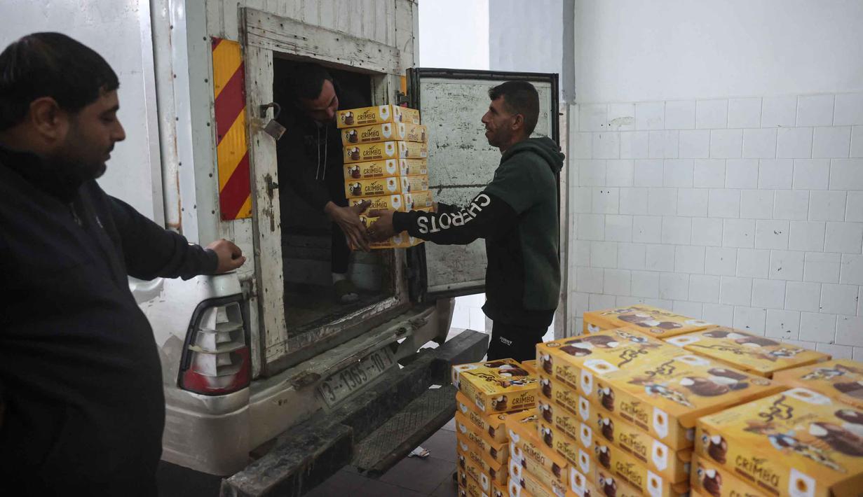 Meski permen Al-Shatawi populer di Palestina, permen ini merupakan produk musiman yang diproduksi oleh sejumlah pabrik lokal di Gaza. Tampak dalam foto, para pekerja Palestina memindahkan kotak-kotak berisi permen yang dikenal secara lokal sebagai permen "al-Shatwi" (kue musim dingin) Crimbo, saat pabrik Al-Arees secara bertahap melanjutkan produksinya setelah terhenti akibat perang, di Deir al-Balah, Jalur Gaza tengah pada 12 Januari 2026, (Bashar Taleb/AFP)