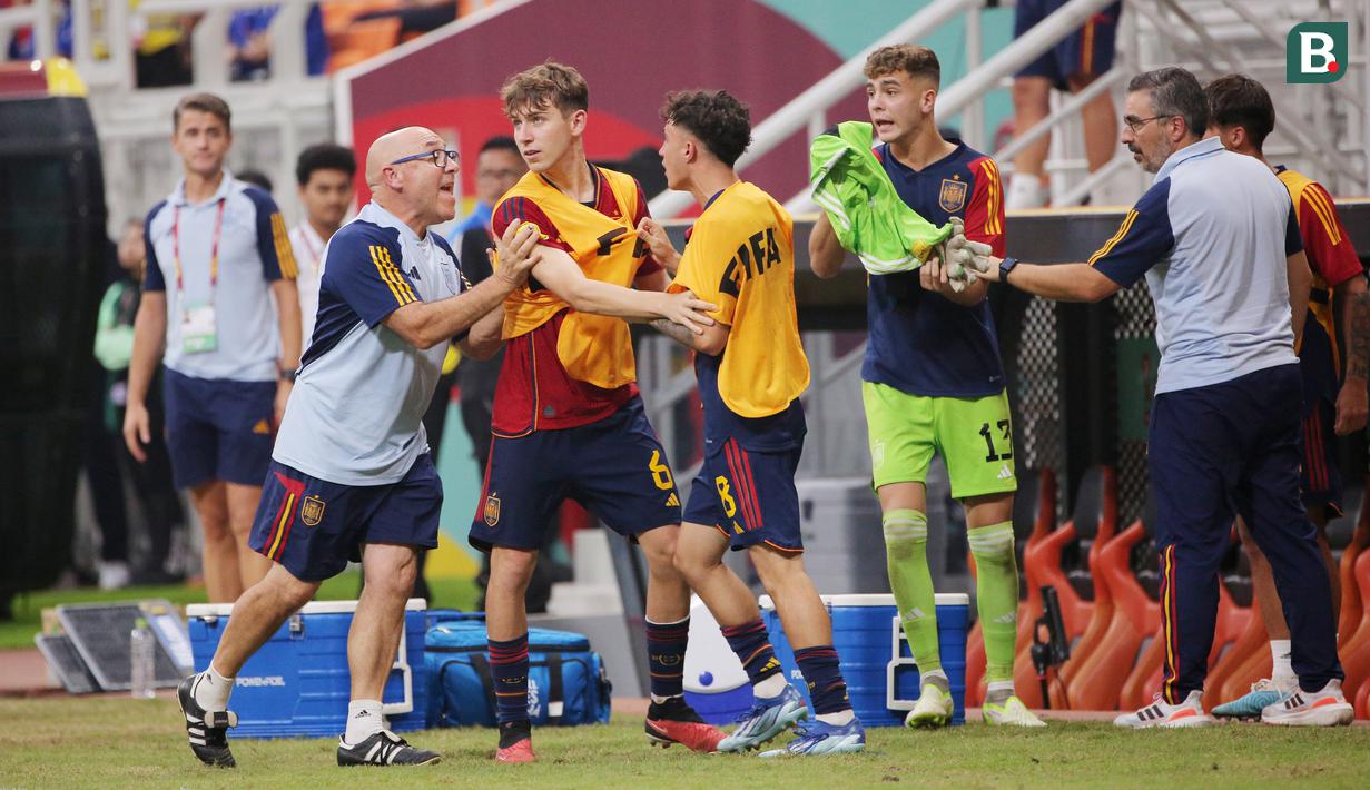 Staf pelatih berusaha menenangkan pemain Timnas Spanyol U-17 yang memprotes wasit saat melawan Jerman U-17 pada babak perempat final Piala Dunia U-17 2023 di Jakarta International Stadium (JIS), Jumat (24/11/2023). (Bola.com/M Iqbal Ichsan)
