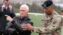 Wapres AS Mike Pence mendengarkan penjelasan kepala angkatan militer AS, Jenderal Vincent Brooks, saat mengunjungi Pos Pengamatan Ouellette di sepanjang Zona Demiliterisasi (DMZ) di perbatasan Korsel dan Korut, Senin (17/4). (AP Photo/Lee Jin-man)