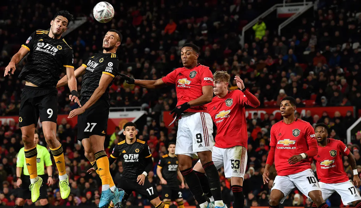 Pemain Wolverhampton Wanderers Raul Jimenez (kiri) menyundul bola ke gawang Manchester United pada putaran ketiga Piala FA di Old Trafford, Manchester, Inggris, Rabu (15/1/2020). Manchester United menang 1-0. (PAUL ELLIS/AFP)