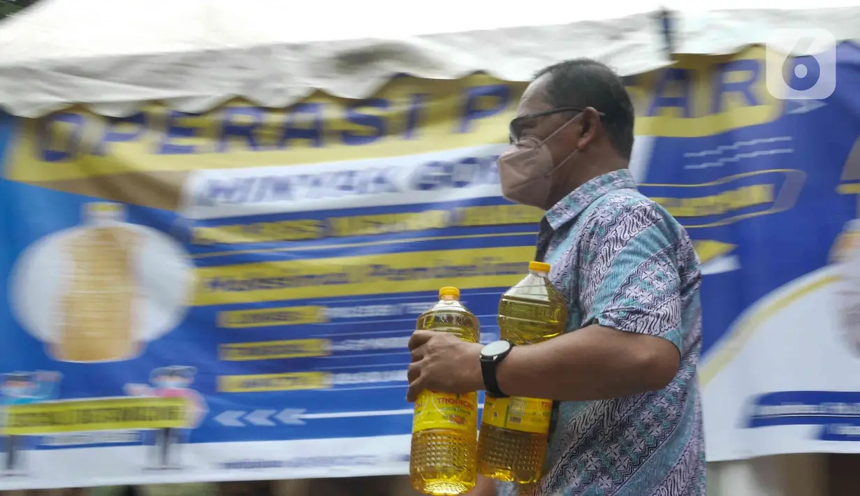 Seorang pria membawa minyak goreng yang dibelinya di Polsek Tebet, Jakarta Selatan, Jumat (4/3/2022). Polres Metro Jakarta Selatan akan menggelar operasi pasar minyak goreng selama enam hari, terhitung mulai hari in, 4 hingga 9 Februari mendatang. (Liputan6.com/Herman Zakharia)