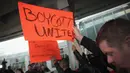 Aksi protes di depan terminal United Airlines terkait pengusiran penumpang di pesawat United Airlines di Bandara Internasional O'Hare, Chicago, AS, Selasa (11/4). (Scott Olson / Getty Images / AFP)