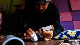 Wajah serius seniman Suriah, Akram Abu Elfoz (37) saat membuat replika Masjid Al-Rawdah dari selongsong peluru dan sisa amunisi perang, di rumahnya di sebelah timur Ibu Kota Damaskus, 3 Juni 2016.  (AFP PHOTO/Sameer Al - Doumy)