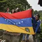 Bendera negara Venezuela dibentangkan saat prosesi pemakaman Jose Francisco Guerrero di San Cristobal, Tachira State, Venezuela (19/5). (AFP/Luis Robayo)