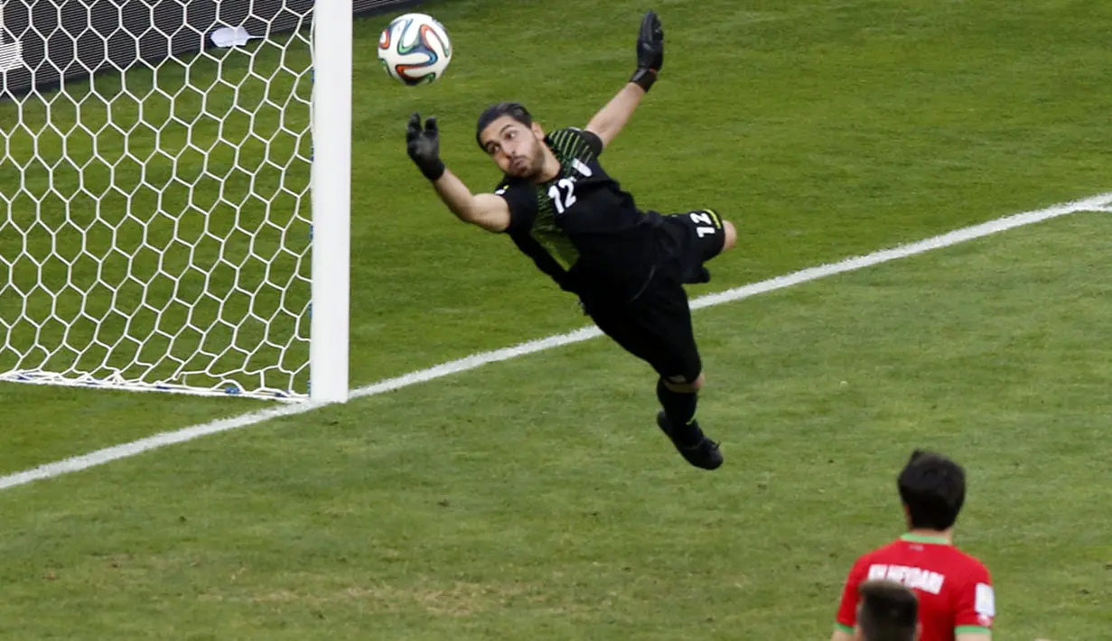 Penjaga gawang Iran, Alireza Haghighi, mencoba menggapai bola hasil tendangan keras pemain Argentina, Lionel Messi, saat berlaga di babak penyisihan Piala Dunia Grup F di Stadion Mineirao, Belo Horizonte, Brasil (21/6/2014). (REUTERS/Leonhard Foeger)