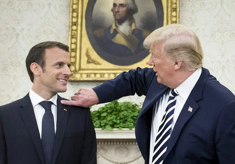 Donald Trump Membersihkan Ketombe di Bahu Presiden Emmanuel Macron (Brendan Smialowski / AFP)
