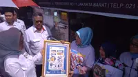 Kepala BPOM Penny K.Lukito memberikan poster sosialisasi pengolahan pangan aman ke salah satu pedagang pempek di Pasar Kuliner 26 Ilir Palembang (Liputan6.com / Nefri Inge)