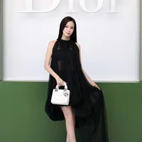 Jisoo mengenakan gaun pesta hitam berbahan silk pleated dari koleksi Dior Autumn-Winter 2026–2027. Ia melengkapi tampilannya dengan berbagai aksesori Dior yang semakin menegaskan kesan elegan dan klasik. [Image Credit: Getty Images/DIOR]