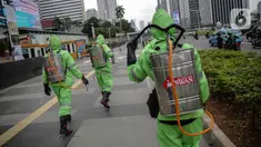 Petugas menyemprotkan cairan disinfektan di ruang publik kawasan pedestrian Sudirman, Jakarta, Kamis (19/3/2020). Penyemprotan dilakukan untuk antisipasi dan pencegahan penyebaran COVID-19 di lingkungan ruang publik yang banyak di gunakan oleh masyarakat. (Liputan6.com/Faizal Fanani)
