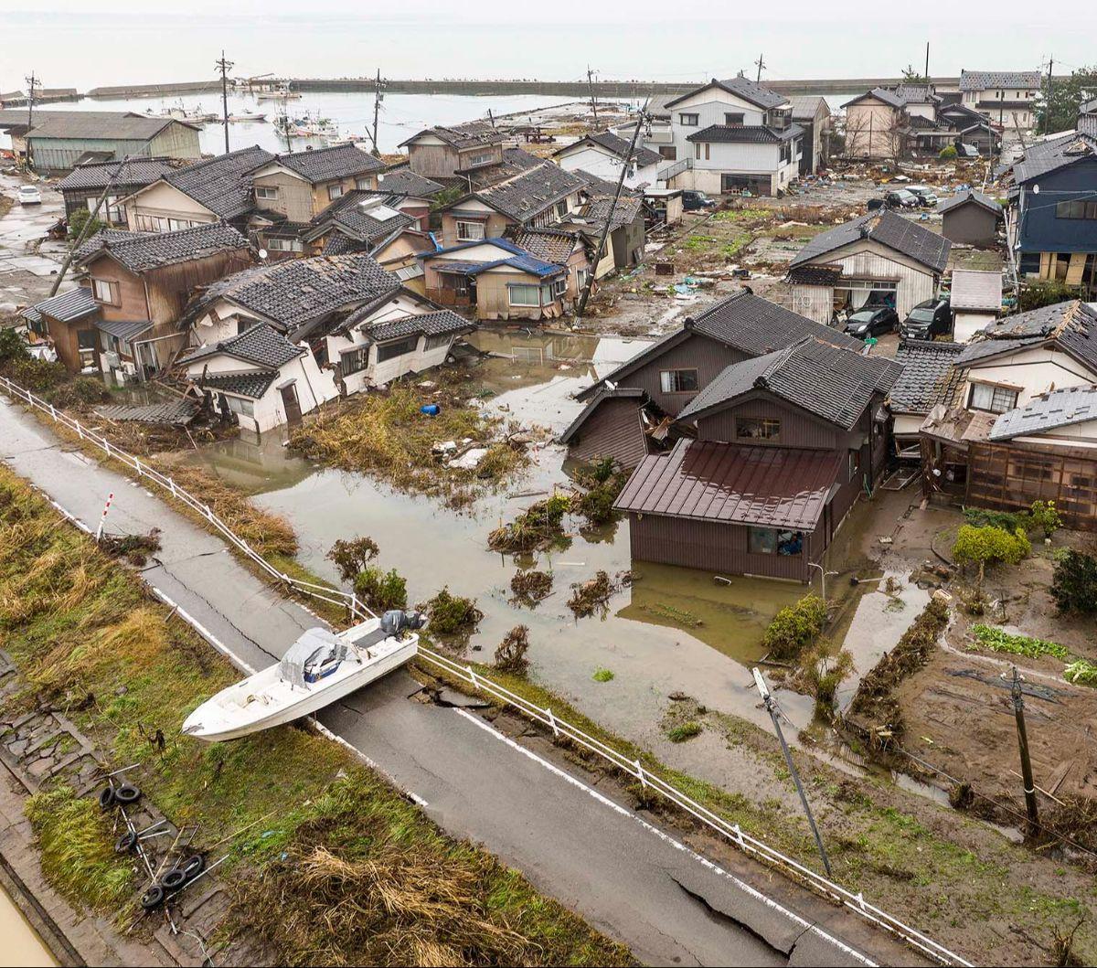 Sebuah kapal terdampar di dekat kawasan permukiman yang rusak parah setelah tersapu tsunami di pesisir Kota Suzu, Prefektur Ishikawa, Jepang, Rabu (3/1/2024). Terjangan tsunami yang dipicu gempa dahsyat 7,5 magnitudo telah membuat Kota Suzu porak-poranda.