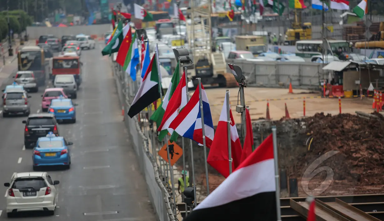 Bendera negara peserta Konferensi Asia Afrika ke-60 terpasang di dinding proyek MRT kawasan Bundaran HI, Jakarta, Selasa (14/4/2015). Persiapan ini dilakukan di sepanjang jalur yang dilalui peserta negara KAA ke-60. (Liputan6.com/Faizal Fanani)
