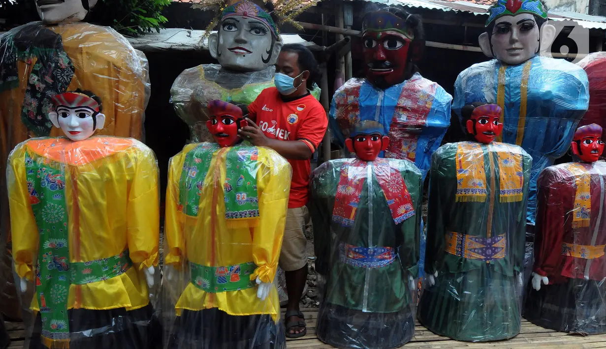Pekerja memeriksa ondel-ondel di Rumah Produksi Ondel-Ondel Jakarta, Setu Babakan, Jakarta Selatan, Minggu (19/9/2021). Setelah stagnan selama dua tahun akibat pandemi COVID-19, produksi dan penjualan ondel-ondel pasca PPKM Level 3 mengalami kenaikan hingga 20 persen. (merdeka.com/Arie Basuki)