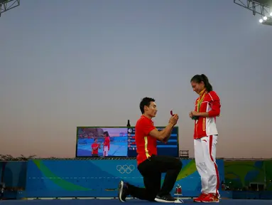 Atlet loncat indah Putri asal Tiongkok, He Zi saat dilamar kekasihnya atlet Penyelam, Qin Kia di atas panggung, saat pengalungan medali perak di ajang Lompat Indah 3 meter pada Olimpiade 2016 di Rio de Janeiro, Brasil, (14/8). (REUTERS/Michael Dalder)