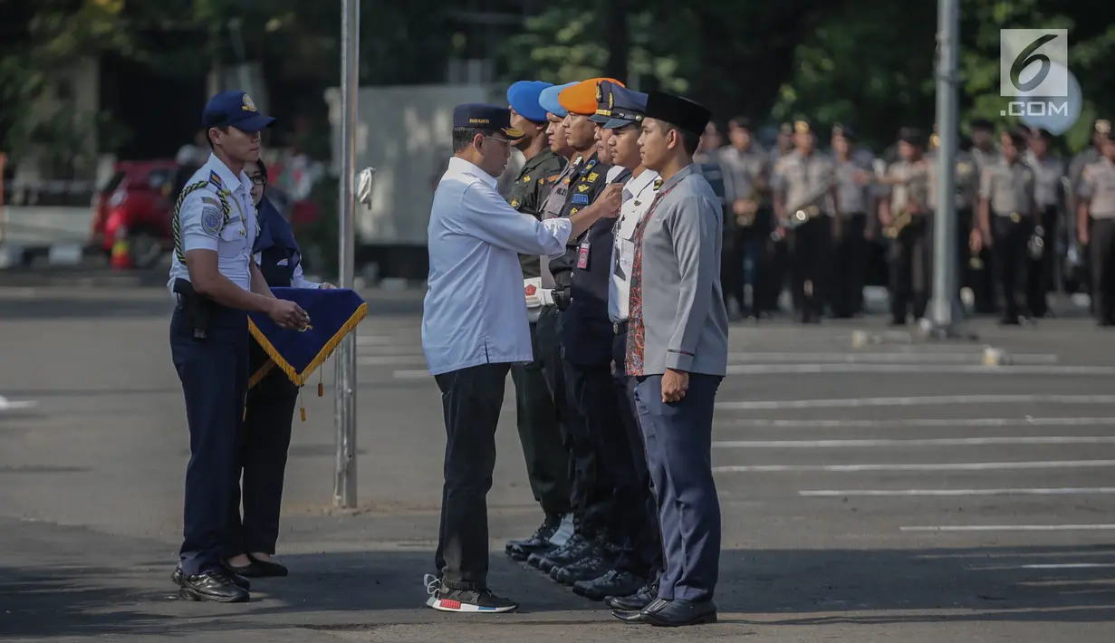Menteri Perhubungan Budi Karya memberikan plakat kepada petugas saat apel persiapan pengamanan dan angkutan lebaran 2019 di Stasiun Gambir, Jakarta, Minggu (26/5/2019). Hal itu terbukti bahwa penjualan tiket kereta api untuk perjalanan H-7 hingga H+7 sudah laku terjual. (Liputan6.com/Faizal Fanani)