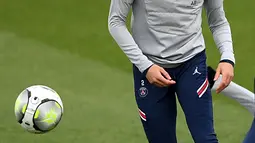 Bek PSG Achraf Hakimi menatap bola selama sesi latihan di tempat latihan klub sepak bola Camp des Loges Paris Saint-Germain, di Saint-Germain-en-Laye, barat Paris pada 10 Februari 2022. PSG akan menjamu Rennes pada lanjutan Ligue 1, Sabtu 12 Februari 2022 dini hari WIB. (FRANCK FIFE / AFP)