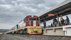 Sebuah kereta tiba di rel tempat penumpang menunggu untuk naik, di stasiun kereta Kisumu, Jumat (17/12/2021). Kereta api Kenya melanjutkan layanan komuter antara Nairobi dan Kisumu setelah tidak beroperasi selama lebih dari 10 tahun. (Brian ONGORO/AFP)