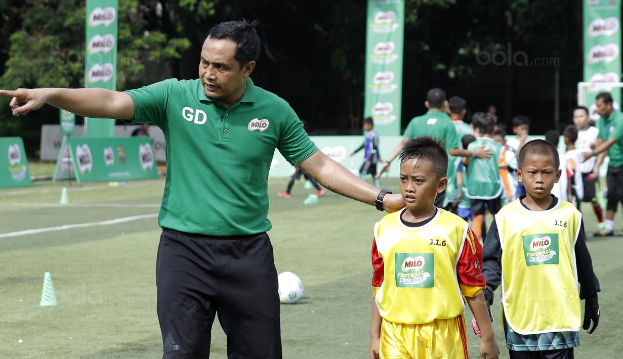Mantan pemain Timnas Indonesia, Gendut Doni, memberikan pelatihan kepada pesepak bola cilik di Lapangan Simprug, Jakarta, Sabtu (16/12/2017). Legenda sepak bola Indonesia ikut berpartisipasi pada MILO Football Clinic Day. (Bola.com/M Iqbal Ichsan)