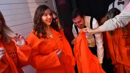 Pengunjung diberikan baju tahanan saat tiba di bar koktail Alcotraz, London , 11 Oktober 2018. Bar berkonsep penjara ini terinspirasi dari karya fiksi terkenal, Shawshank Redemption dan serial Netflix bertajuk 'Orange Is a New Black'. (BEN STANSALL / AFP)