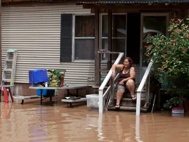 Honorina Paniagua duduk di tangga rumahnya saat banjir merendam kawasan Richmond, Texas, Selasa (31/5). Bencana banjir terjadi lantaran Sungai Brazos meluap akibat hujan deras yang mengguyur wilayah tersebut. (REUTERS/Daniel Kramer)