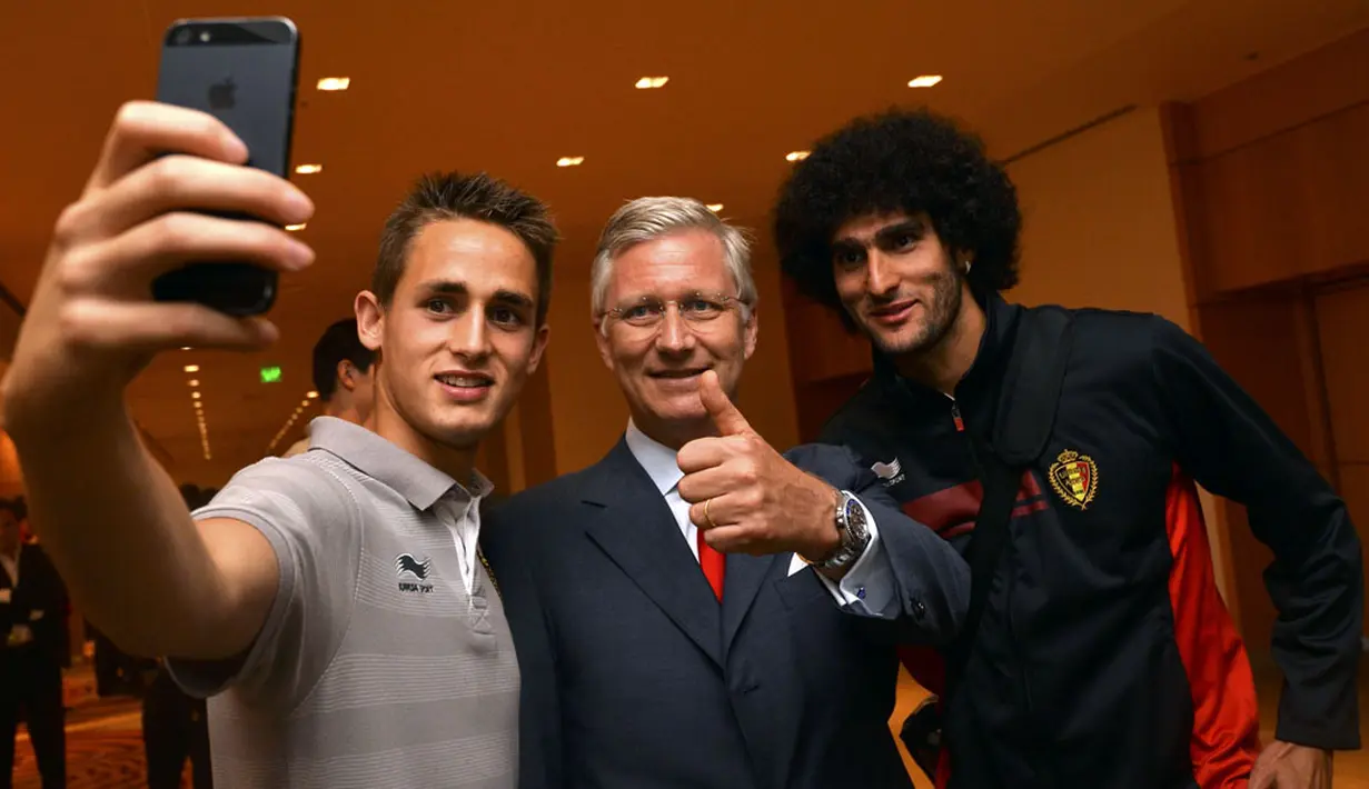 Dua penggawa Timnas Belgia, Adnan Januzaj (kiri) dan Marouane Fellaini tidak menyia-nyiakan kesempatan untuk berfoto bersama Raja Philippe (tengah), Brasil, (23/6/2014). (REUTERS/Benoit Doppagne)