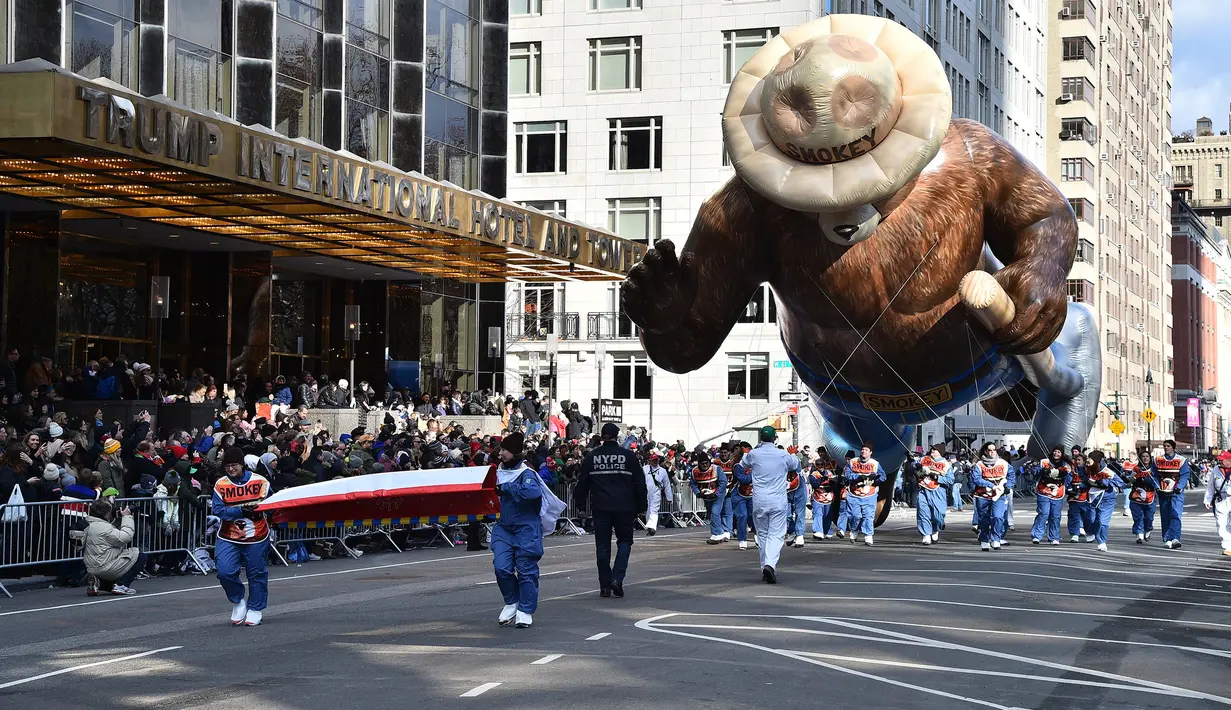 Peserta menerbangkan balon  bernama Smokey the Bear dalam parade perayaan Hari Thanksgiving di kawasan Sixth Avenue, New York, Kamis (28/11/2019). Parade yang membelah jalanan kota New York ini selalu ditunggu setiap tahunnya. (Theo Wargo/Getty Images/AFP)