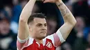 Gelandang Arsenal, Granit Xhaka berselebrasi usai mencetak gol ke gawang Manchester United selama pertandingan lanjutan Liga Inggris di Stadion Emirates di London (10/3). Arsenal menang 2-0 atas MU. (AFP Photo/Ian Kington)