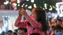 Seorang anak mengambil foto di sebuah pasar malam di Shanghai, China timur (6/6/2020). Sejumlah bar, museum, toko buku, pusat perbelanjaan, dan kompleks komersial besar ikut serta dalam festival itu dengan jam operasional yang diperpanjang. (Xinhua/Ding Ting)