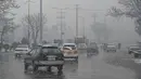 Komuter berjalan di sepanjang jalan saat hujan salju lebat di Kabul (4/1/2022). Beberapa kecelakaan terjadi pada Senin (3/1) di tengah kondisi lalu lintas yang kacau setelah hujan salju lebat. (AFP/Mohd Rasfan)