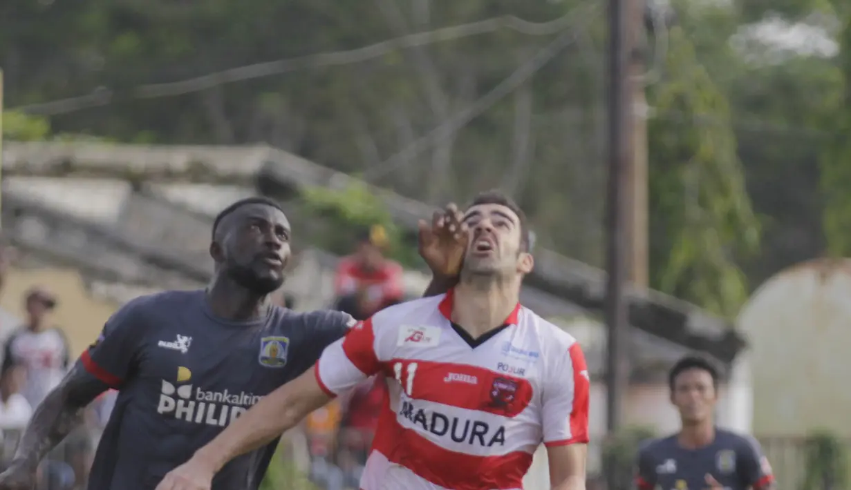 Penyerang Madura United, Pablo Aracil, duel bola atas dengan bek Persiba Balikpapan, Boakay Edy Fodai, pada laga uji coba di Stadion Ahmad Yani, Sumenep, Sabtu (20/2/2016). (Bola.com/Vitalis Yogi Trisna)