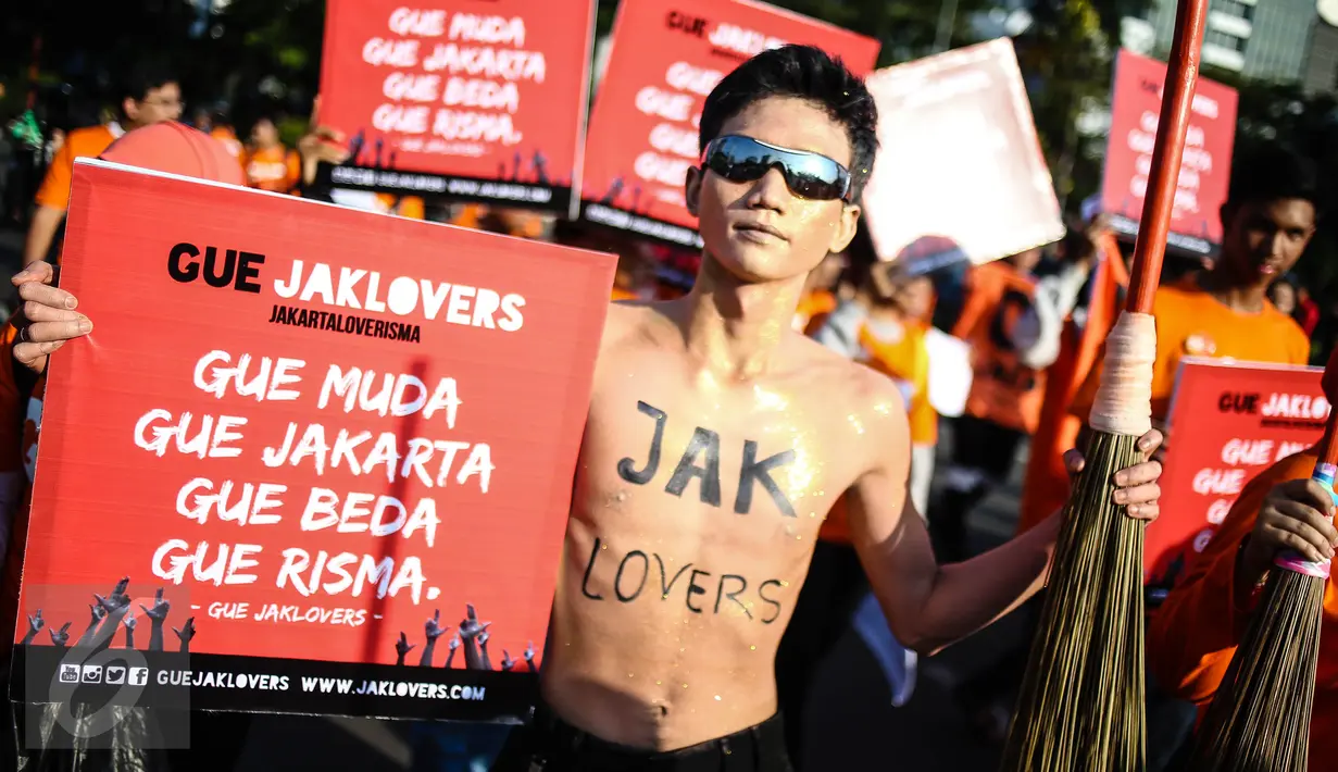 Seorang anak muda berpartisipasi dalam aksi simpatik mendukung Wali Kota Surabaya Tri Rismaharini maju sebagai cagub pada Pilkada DKI 2017, di Bundaran Patung Kuda, Jakarta, Minggu (31/7). Mereka membawa simbol sapu lidi. (Liputan6.com/Faizal Fanani)