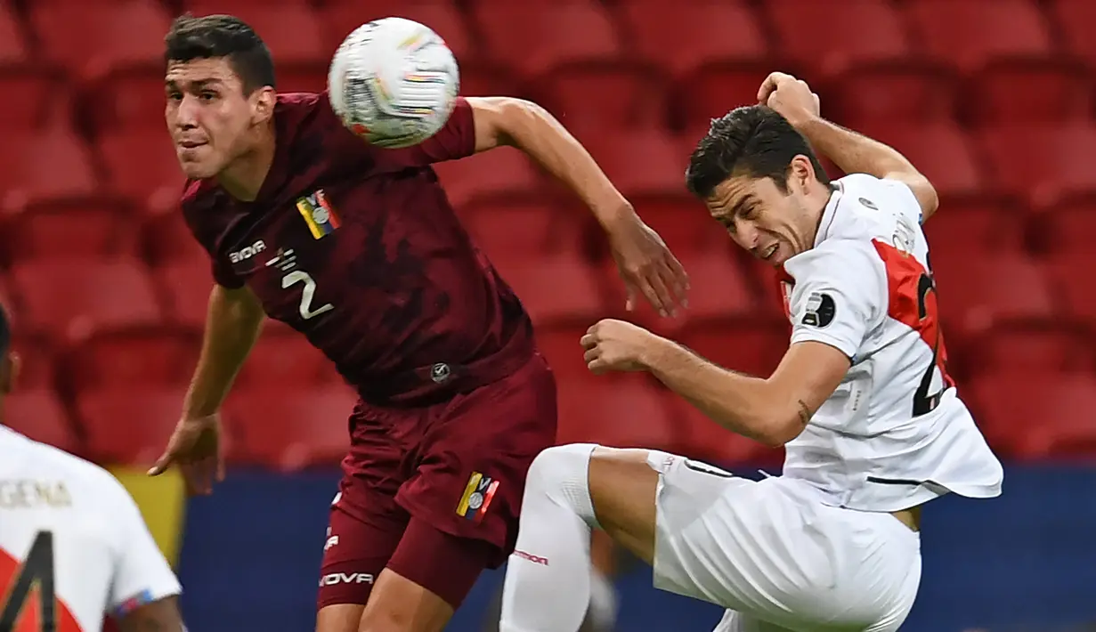 Bek timnas Venezuela, Nahuel Ferraresi dan penyerang Peru berebut bola pada laga terakhir penyisihan Grup B  Copa America 2021 di Estadio Nacional Mane Garrincha, Minggu (27/6/2021). Menghadapi Venezuela, Peru menang tipis dengan skor 1-0. (EVARISTO SA / AFP)
