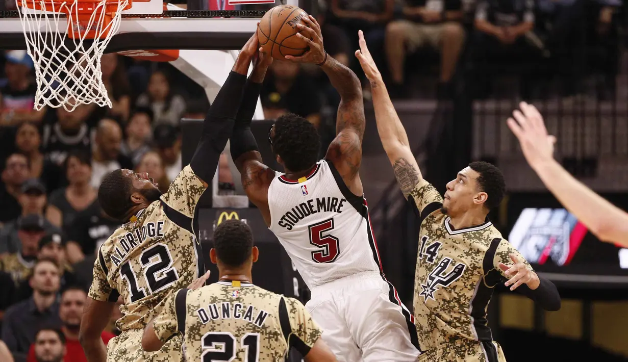 Pemain San Antonio Spurs, LaMarcus Aldridge (12) melakukan blok tembakan pemain Miami Heat  Amar'e Stoudemire (5) pada lanjutan NBA di AT&T Center, Texas, Kamis (24/3/2016). San Antonio Spurs menang 112-88. (Mandatory Credit: Soobum Im-USA TODAY Sports)