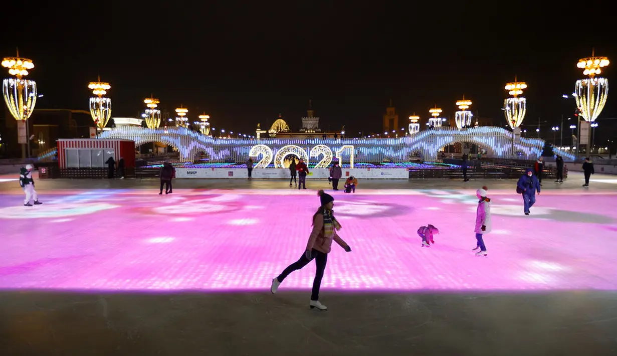 Sejumlah orang berseluncur saat pembukaan arena seluncur es di VDNKh (Pameran Prestasi Ekonomi Nasional), Moskow, Rusia, Jumat (27/11/2020). Area tersebut terbuat dari lapisan es buatan lebih dari 20.000 meter persegi. (AP Photo/Alexander Zemlianichenko)