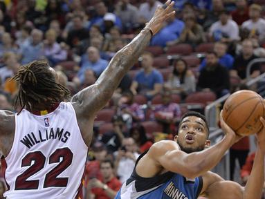 Pemain Minnesota Timberwolves Karl-Anthony Towns #32 berusaha melakukan tembakan saat dihadang pemain Miami Heat, Derrick Williams #22 pada laga NBA preseason basketball game di Louisville, (15/10/2016). (AP/Timothy D. Easley)