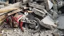 Sebuah motor tertimpa reruntuhan rumah roboh di di  Jalan Pulo, Tanah Tinggi, Johar Baru, Jakarta Pusa, Jumat (26/4). Tiga orang dewasa berhasil dievakuasi, namun masih terdapat 2 ibu-ibu dan 4 anak-anak di dalam rumah tersebut. (Liputan6.com/Herman Zakharia)