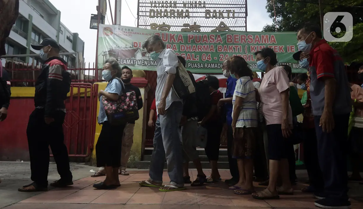 Warga antre untuk menerima makanan berbuka puasa di Vihara Dharma Bhakti, Petak Sembilan, Jakarta, Kamis (7/4/2022). Yayasan Vihara Dharma Bhakti menyediakan sekitar 200 porsi menu berbuka puasa bagi warga sekitar untuk lebih mempererat persaudaraan umat beragama. (Liputan6.com/Helmi Fithriansyah)
