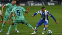 Pemain Espanyol, Raul de Tomas, berusaha melewati pemain Real Madrid, Raphael Varane, pada laga La Liga di Stadion Cornella-El Prat, Minggu (28/6/2020). Real Madrid menang 1-0 atas Espanyol. (AP/Joan Monfort)