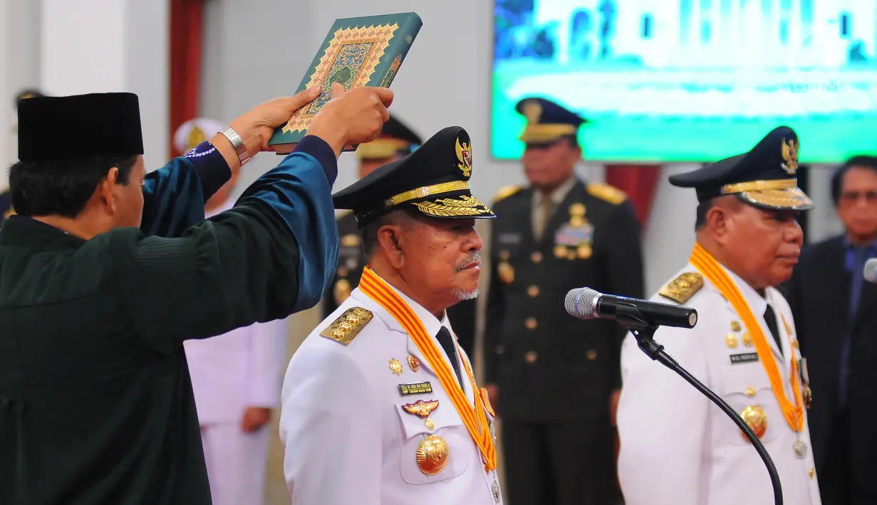Gubernur dan Wakil Gubernur terpilih Maluku Utara Abdul Gani Kasuba (kiri) dan Al Yasin disumpah dengan kitab suci Alquran saat pelantikan di Istana Negara, Jakarta, Jumat (10/5/2019). Mahkamah Konstitusi (MK) memutuskan keduanya sebagai pemenang Pilgub Malut 2018. (Liputan6.com/Angga Yuniar)