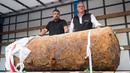 Pakar bom Rene Bennert dan Dieter Schweizler berpose di dekat bom Perang Dunia II di Frankfurt, Jerman, (3/9). Lebih dari 60.000 orang dievakuasi setelah sebuah bom 1.400 ton Perang Dunia II (tambang udara HC 4000) ditemukan. (AFP Photo/Thomas Lohnes)