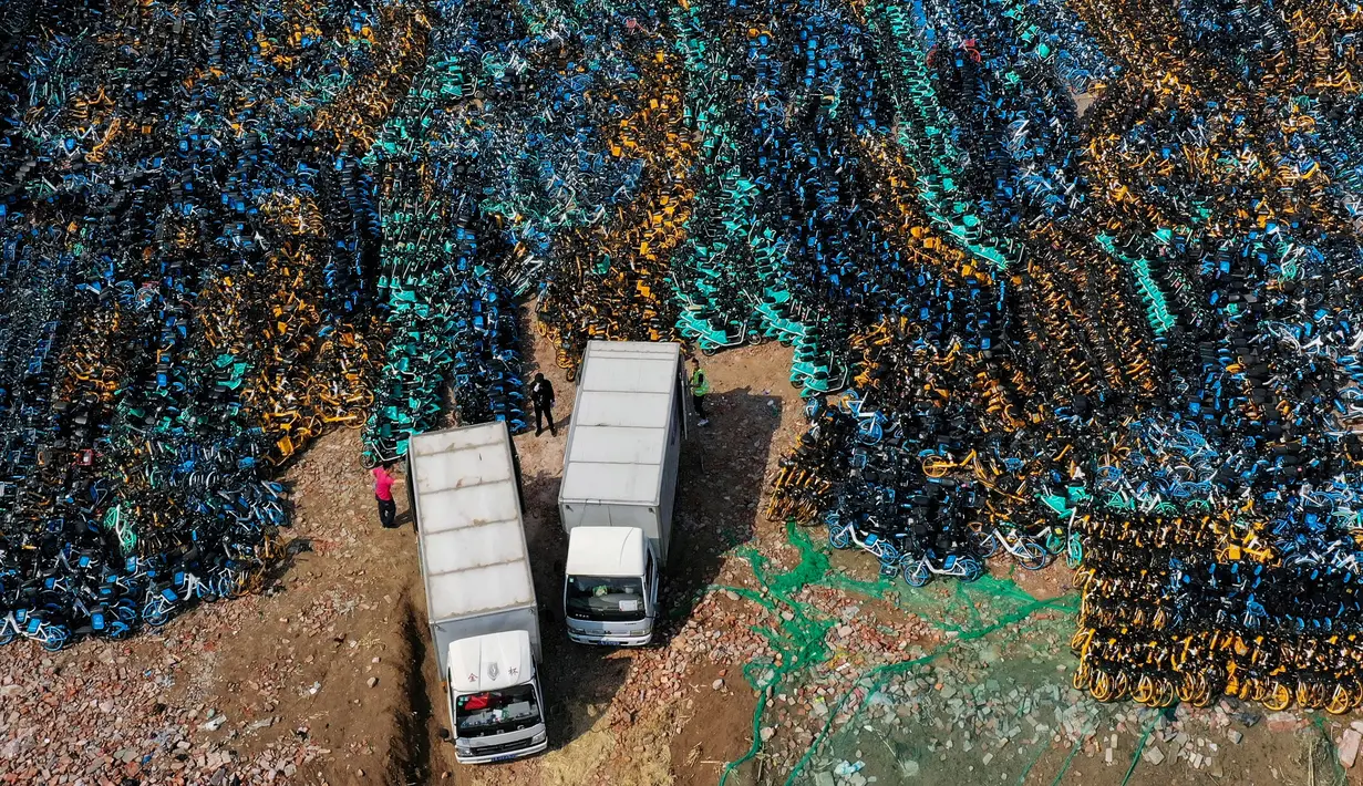 Foto udara pada 19 April 2021 ini menunjukkan tumpukkan sepeda publik yang ditinggalkan di Shenyang, timur laut China. Ribuan sepeda yang awalnya disewakan secara online tersebut, dibiarkan terbengkalai karena banyak operator penyewaan sepeda yang bangkrut akibat pandemi Covid-19. (STR/AFP)