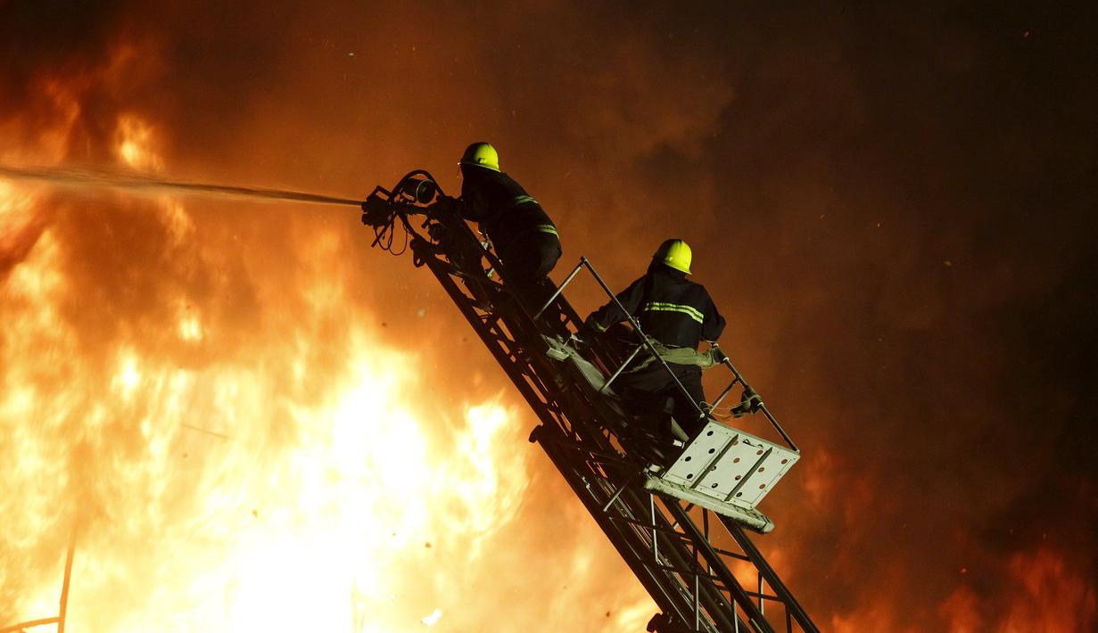 Petugas pemadam kebakaran bekerja memadamkan api di pasar Minglar di Yangon, Myanmar, Sabtu (9/1/2016). Penyebab kebakaran masih dalam penyelidikan . (Reuters/Soe Zeya Tun)