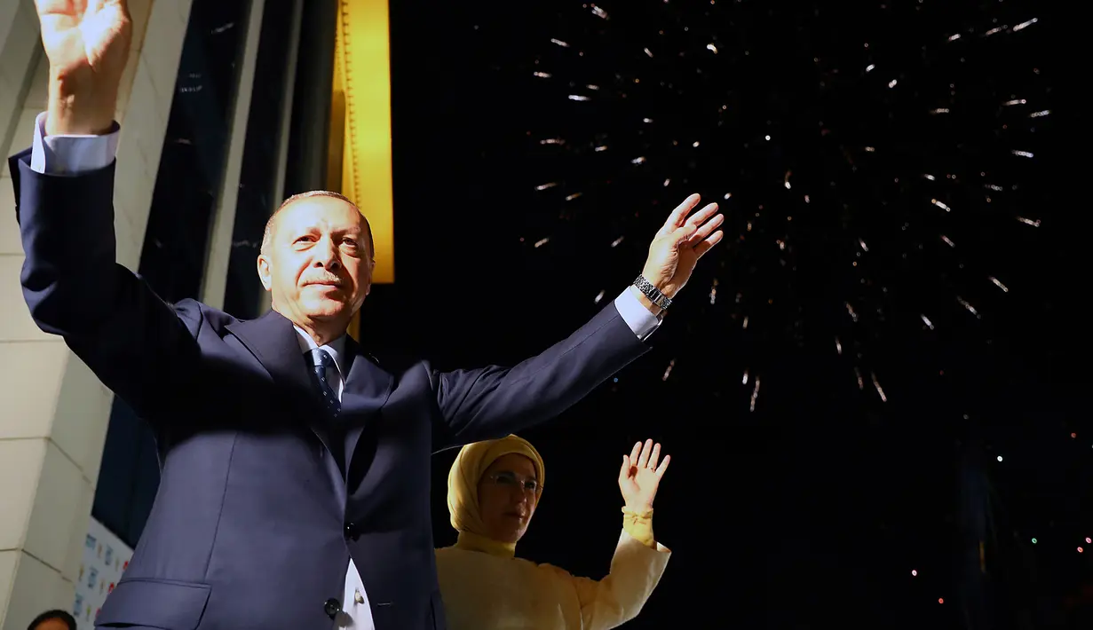 Presiden Turki Recep Tayyip Erdogan dan istri, Emine menyapa pendukung Partai AKP di Ankara, Turki, Senin (25/6). Pemilu ini untuk pertama kalinya digelar sejak Turki mengubah sistem parlementer ke presidensial. (Presidency Press Service via AP, Pool)