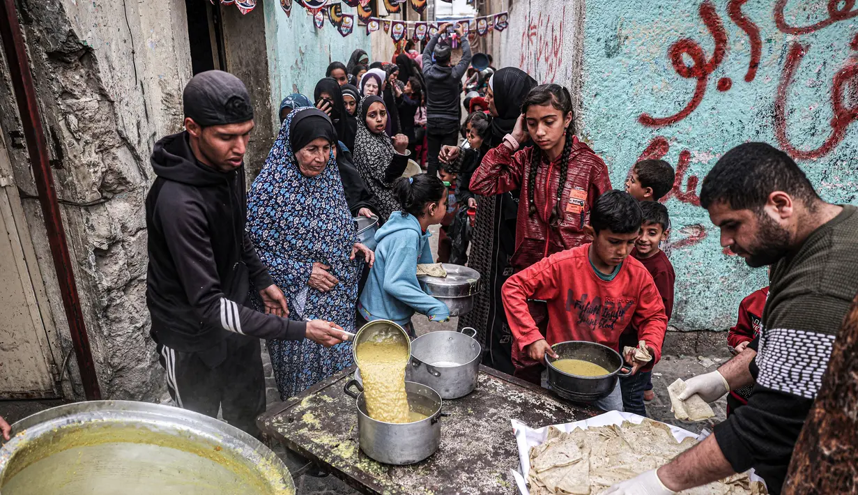 Sebuah organisasi amal menyediakan makanan untuk berbuka puasa bagi anak-anak dan pengungsi Palestina lainnya. (SAID KHATIB/AFP)