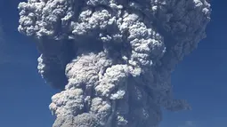 Gunung Sinabung yang mengeluarkan abu tebal terlihat dari kota Berastagi di Sumatera Utara (19/2). Gunung Sinabung kembali menyemburkan abu vulkanik tebal dengan tinggi kolom 5.000 meter. (AFP Photo/Anto Sembiring)