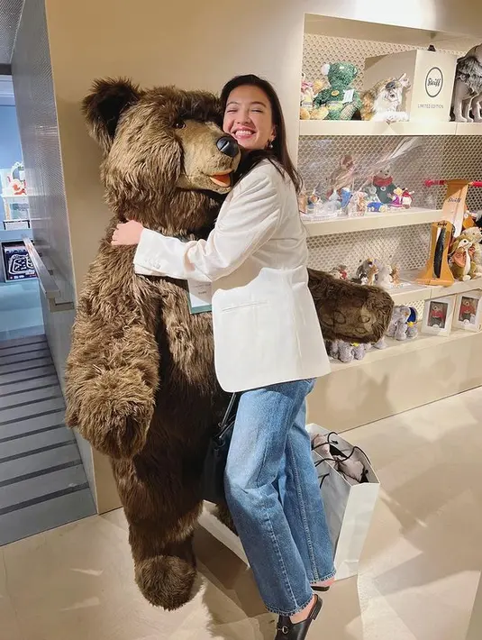 Raline Shah berkesempatan untuk memeluk sebuah boneka raksasa saat berkunjung ke sebuah toko. Ia pun mengenakan blazer putih dengan straight jeans tas hitam. (instagram/ralineshah)