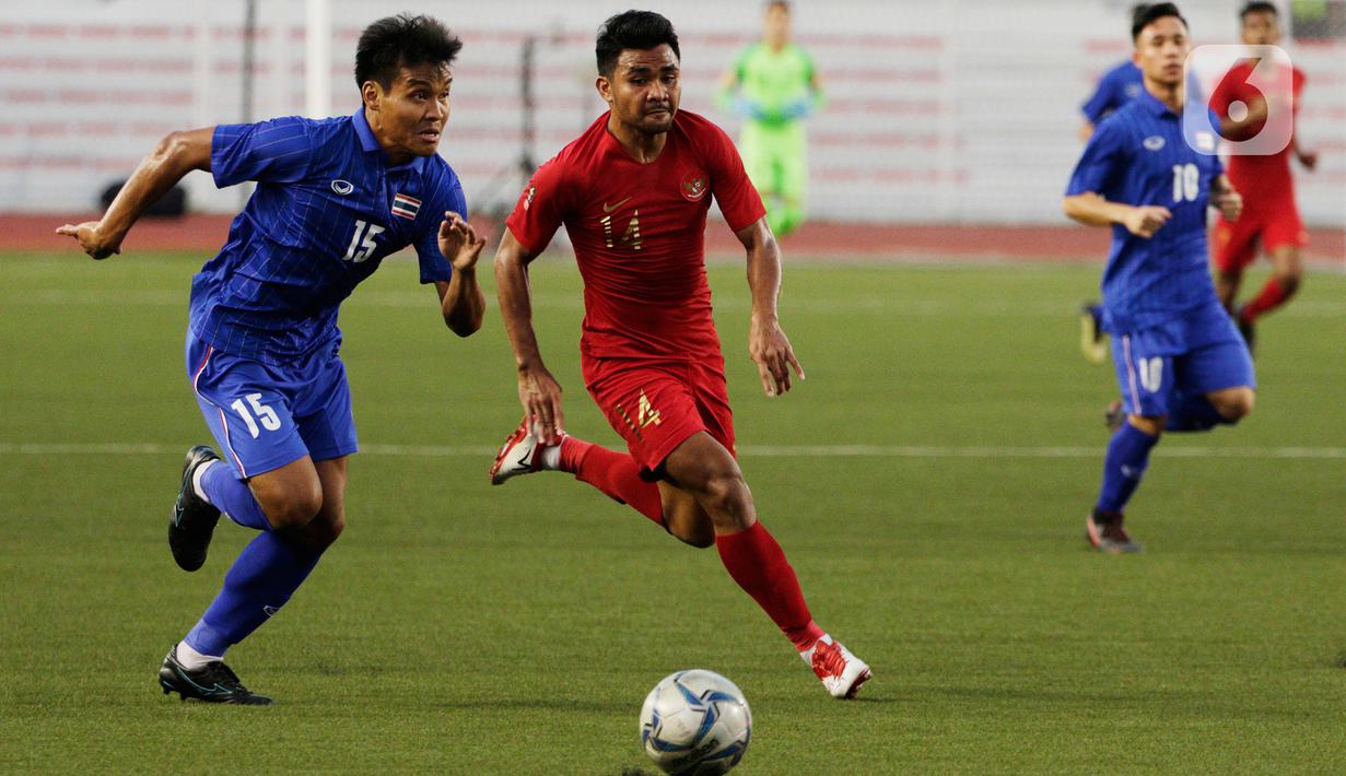 Bek Thailand Saringkan Promsupa beradu cepat dengan bek Timnas Indonesia U-22 Asnawi Mangkualam pada laga SEA Games 2019 di Stadion Rizal Memorial, Manila, Filipina, Selasa (26/11/2019). Indonesia menang 2-0 atas Thailand. (Bola.com/M Iqbal Ichsan)