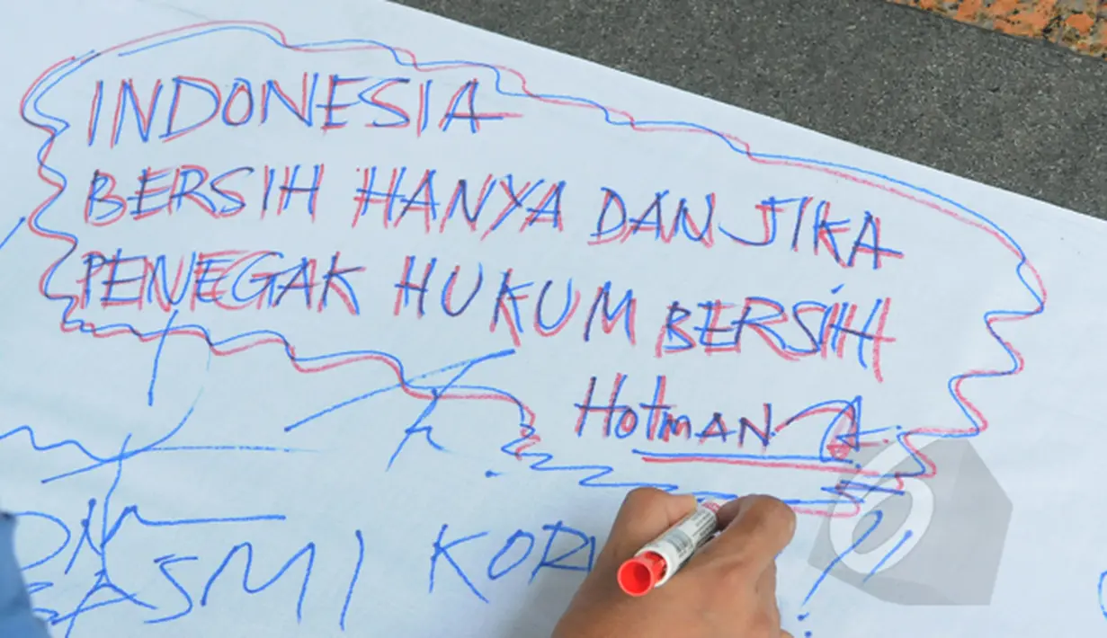 Sebuah pesan yang ditulis pegawai KPK di atas kain putih saat aksi unjuk rasa menolak putusan pimpinan KPK yang melimpahkan kasus Komjen Pol Budi Gunawan ke Kejaksaan Agung di halaman gedung KPK, Jakarta, Selasa (3/3/2015). (Liputan6.com/Herman Zakharia)